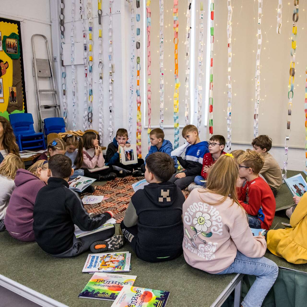 Kinder sitzen im Klassenraum und hören einer Vorlesung zu.